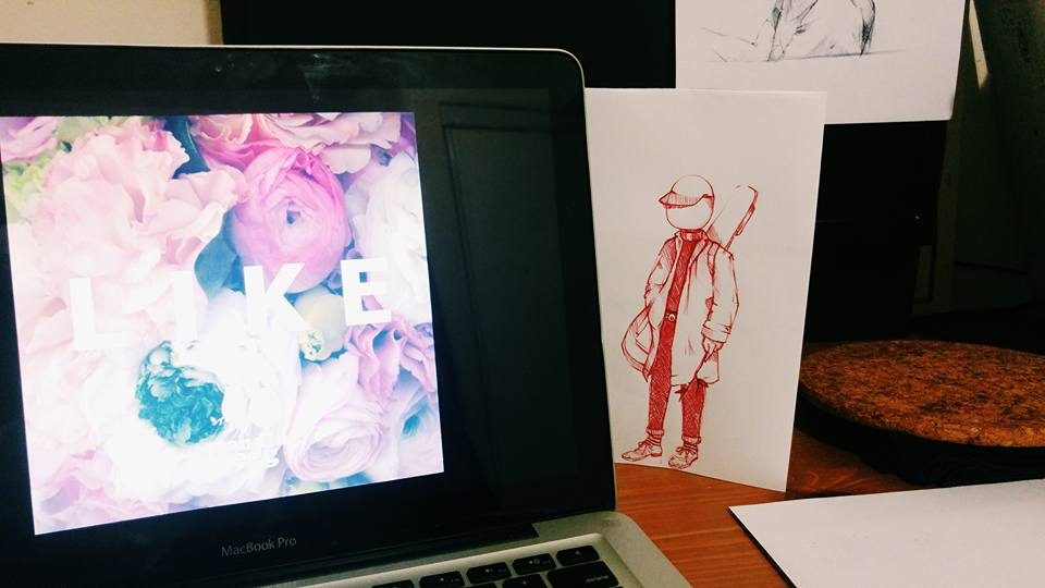 A desk with a figure illustration and a laptop showing flowers